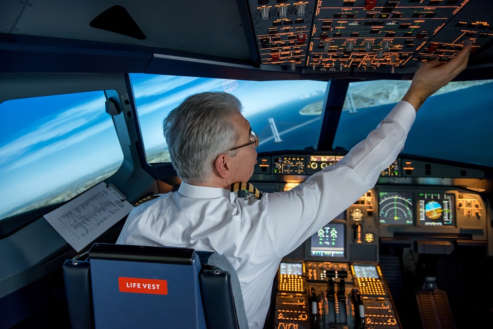 pilot activating in-flight systems in the cockpit